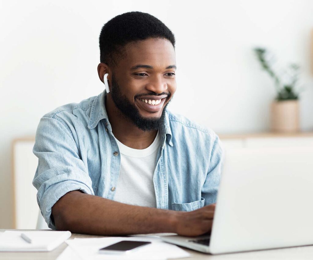 Educate Kansas - Man smiling at his computer while doing online classes