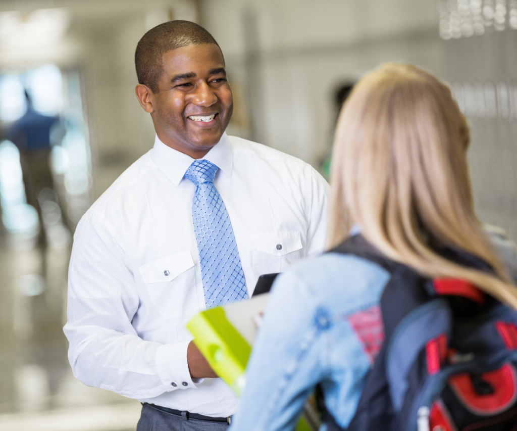 Principal talking to student in the hallway